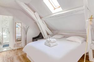a bedroom with a white bed with a skylight at Escale pro & détente à 3 min de la gare - Parking - WIFI - PS4 in Corbeil-Essonnes