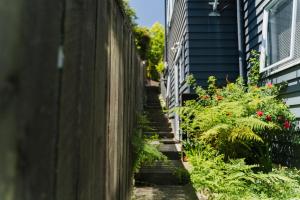 a stairway leading up to a house with flowers at Doubtless Bay Retreat in Coopers Beach