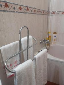 un bagno con asciugamani e portasciugamani accanto a una vasca di Refúgio d' Aldeia a Reguengos de Monsaraz