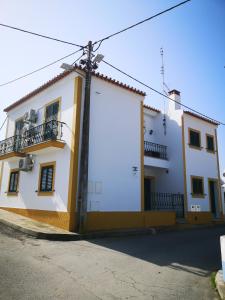 un edificio bianco e giallo sul lato di una strada di Refúgio d' Aldeia a Reguengos de Monsaraz