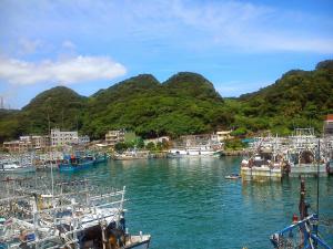 a group of boats docked in a harbor with mountains at Yun Cheng Homestay in Jiufen