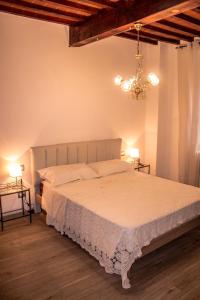 a bedroom with a large bed with a chandelier at Fonte alle Ninfe B&B in Castiglione dʼOrcia