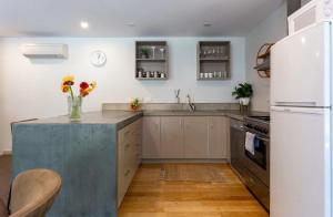 una cucina con elettrodomestici bianchi e piano di lavoro in cemento di Alpine Retreat a Queenstown