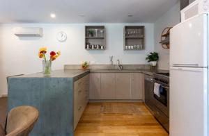 a kitchen with white appliances and a concrete counter top at Alpine Retreat in Queenstown