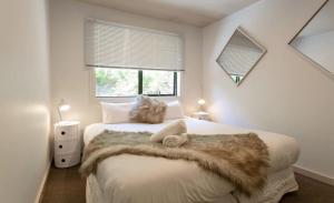 a bedroom with a bed with a furry blanket on it at Alpine Retreat in Queenstown +13 photos
