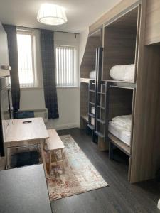 a dorm room with bunk beds and a desk and a table at Eleanor Rigby apts Stanley Street in Liverpool