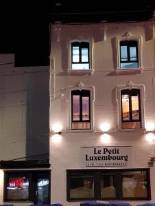 un bâtiment blanc avec un panneau sur son côté dans l'établissement Le petit Luxembourg, à Montignies-sur-Sambre