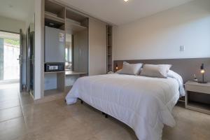 圣洛伦索SIETE LUNAS DE San Lorenzo的卧室里有一张白色的大床和一台电视 更多54张照片