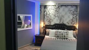 - une chambre dotée d'un lit avec un mur bleu dans l'établissement Le petit Luxembourg, à Montignies-sur-Sambre
