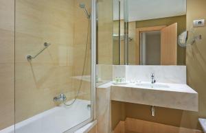 a bathroom with a sink and a shower at NH Bilbao Deusto in Bilbao