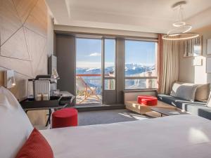 a hotel room with a bed and a large window at Hotel Mercure - Les Arcs 1800 & SPA in Arc 1800