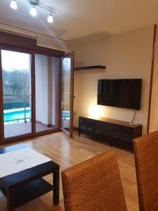 a living room with a television and a table and chairs at Apartamento La Esperanza in Cangas de Onís