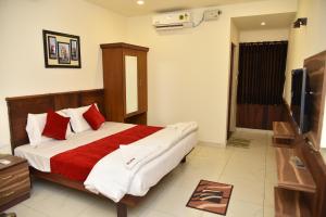 una camera da letto con un grande letto con cuscini rossi e bianchi di Sree Ganesh Inn a Palni