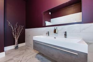 La salle de bains est pourvue d'un lavabo blanc et d'un miroir. dans l'établissement Nydsley Hall by Maison Parfaite - 4 Luxury Apartments - 2 with Hot Tubs, à Pateley Bridge