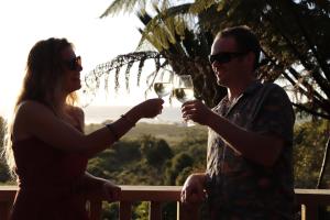 a man and woman holding glasses of white wine at Treescapes - Rainforest Hot Tub 2km from Punakaiki in Punakaiki