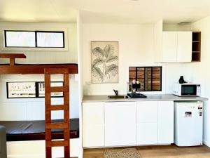 a kitchen with white cabinets and a bunk bed at The Beach Arrawarra in Arrawarra +56 photos