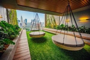two swings on a balcony with green grass at Ceylonz Starlight Suites Bukit Bintang in Kuala Lumpur