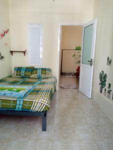 1 dormitorio con 1 cama y puerta que da a un pasillo en Ngôi Sao Homestay, en Vĩnh Hy