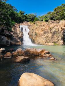 una cascata in mezzo a un fiume con rocce di Ngôi Sao Homestay a Vĩnh Hy