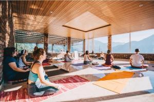 - un groupe de personnes assises dans une salle de yoga dans l'établissement Hill Top Swiss Cottage, à Rishikesh