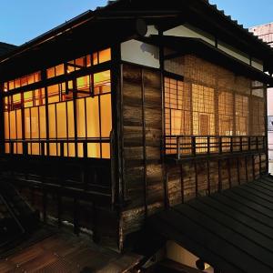 Okiya Guest House & Tapas Bar في Kiryu: مبنى خشبي مع نوافذ على سطح السفينة
