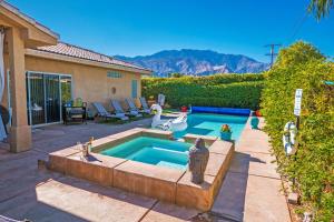 a backyard with a swimming pool and a house at Swan House in Palm Springs