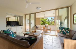 a living room with a couch and a table at Silkari Reflections of Port Douglas in Port Douglas