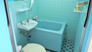 Baño azul con lavabo y aseo en Pension New Hamanoso, en Ishigaki Island