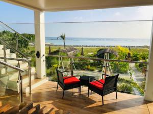 a balcony with a table and chairs and a view of the ocean at Reef Edge Thulusdhoo, Maldives in Thulusdhoo