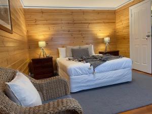 a bedroom with two beds and two chairs at Sails - elegant, spacious beach villa in Port Fairy