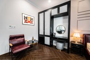 a living room with a chair and a mirror at Padona Hotel in Da Lat