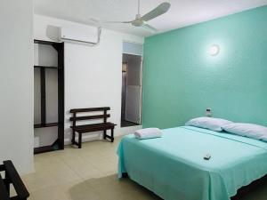 a bedroom with a bed and a desk at Paziflora Hostel in Puerto Escondido