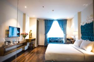 a hotel room with a large bed and a window at Blue Diamond Luxury Hotel in Ho Chi Minh City
