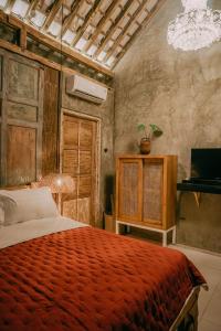 um quarto com uma cama grande e um cobertor vermelho em west room at Semadi Living em Sukawati