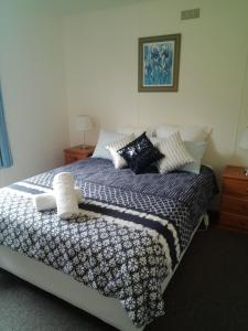 a bedroom with a bed with pillows on it at GreenGate Cottages in Strahan