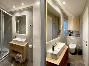 un bagno con due lavandini, una doccia e un WC di MarinaVilla a Nykøbing Falster