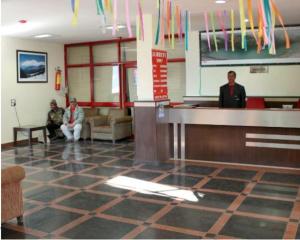 a waiting room with people sitting at a counter at GMVN Auli in Joshīmath