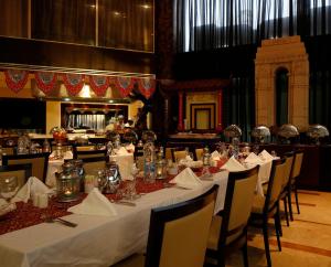 فندق هوليداي إن الرياض ازدهار في الرياض: غرفة طعام مع طاولات وكراسي مع قماش الطاولة البيضاء