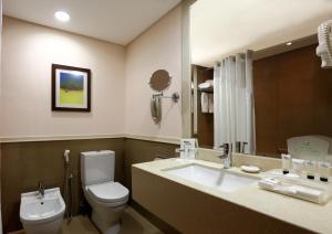 ein Badezimmer mit einem weißen WC und einem Waschbecken in der Unterkunft Holiday Inn Riyadh Izdihar, an IHG Hotel in Riad