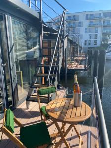 - une table et des chaises sur un balcon avec une bouteille de vin dans l'établissement MarinaVilla, à Nykøbing Falster