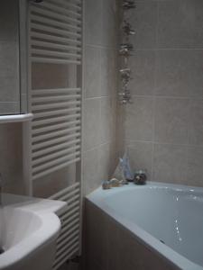 un bagno con vasca e lavandino di Villa Wohli 4 Sterne FERIENWOHNUNG AM HARZ a Nordhausen