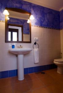a bathroom with a sink and a mirror and a toilet at Casa Concepción in Grazalema