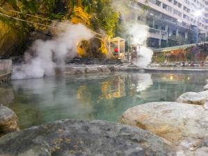 una piscina de agua con vapor saliendo de ella en 知本溫泉の旅宿 en Wenquan