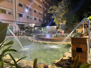 una piscina con una fuente en un patio por la noche en 知本溫泉の旅宿, en Wenquan