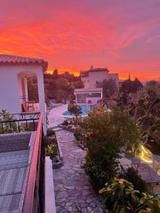 a sunset over a villa with a stone walkway at Maxima Sunset in Sainte-Maxime