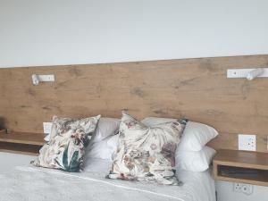 モッセル・ベイにあるVilla Vistaのベッド(枕付)、木製ヘッドボード