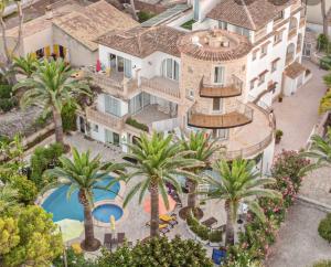 uma vista aérea de um edifício com piscina e palmeiras em Villa Piccola by Cassai em Colonia Sant Jordi