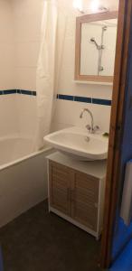 a bathroom with a sink and a tub and a mirror at Les Cimes, Chaleureux studio 4 pers, 50m du télécabine, vue dégagée sur les pistes, DRAPS NON COMPRIS in Saint-Jean-dʼAulps