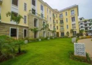 a large apartment building with a green yard at Areia De Goa - Sunrise By Leela Homes in Arpora