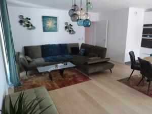 a living room with a couch and a table at Magnifique F3, 75m² avec Parking privé et Terrasse in Strasbourg